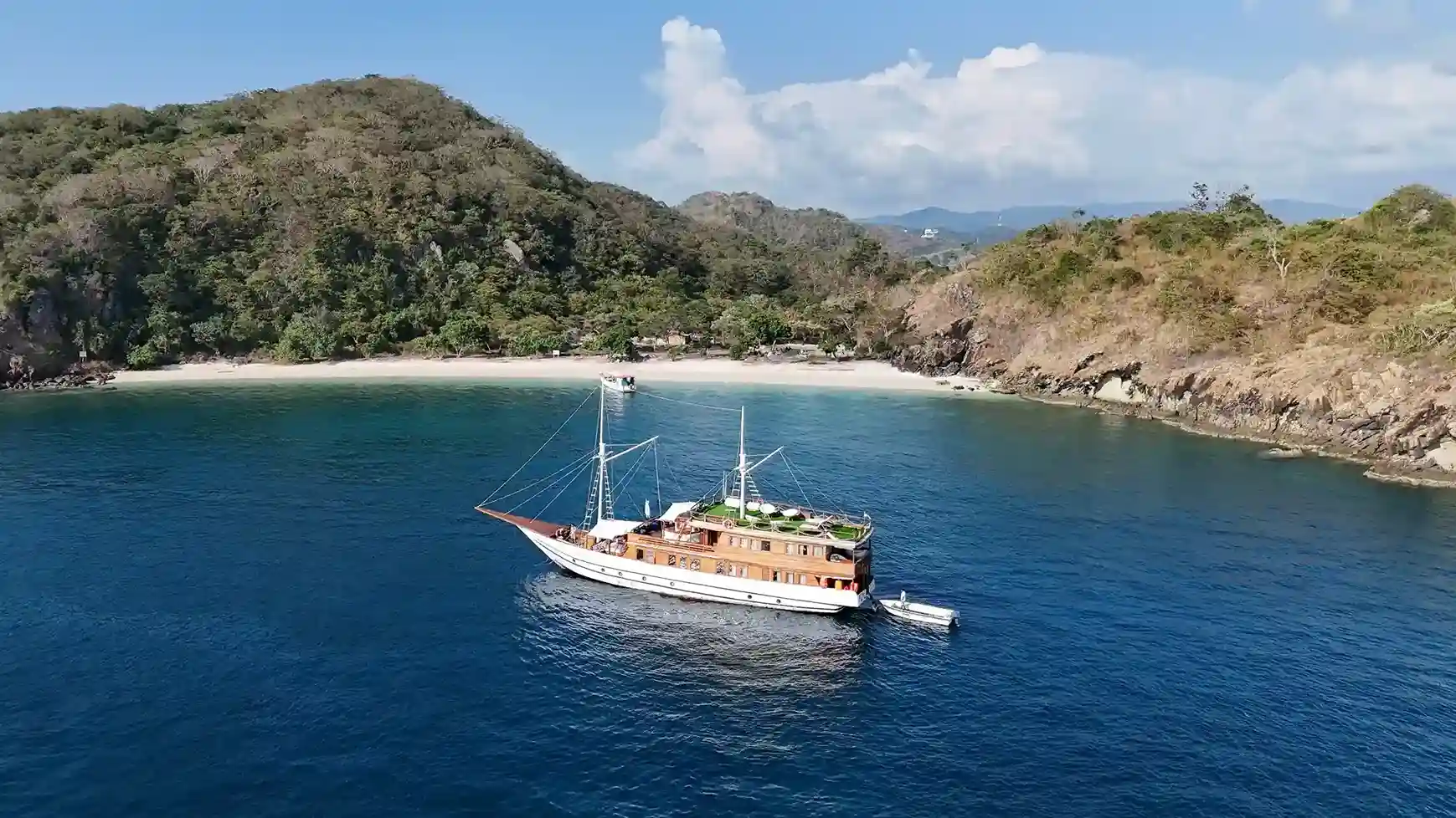 Kapal bercahaya di pelabuhan Labuan Bajo saat senja di bawah kawanan kalong